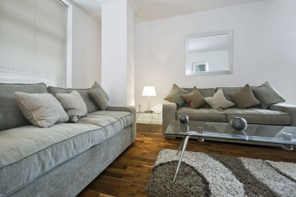 Moderne Wohnlandschaft mit Sofakissen, deren Bezüge durch aufgenähte Klettverschlüsse sicher fixiert sind.